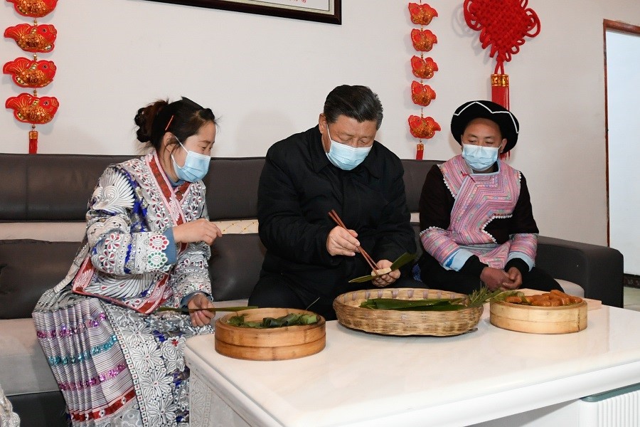 2021年2月3日下午，習(xí)近平在貴州畢節(jié)市黔西縣新仁苗族鄉(xiāng)化屋村苗族村民趙玉學(xué)家，同一家人邊聊家常邊制作當(dāng)?shù)貍鹘y(tǒng)節(jié)日食品黃粑。新華社記者 李學(xué)仁 攝