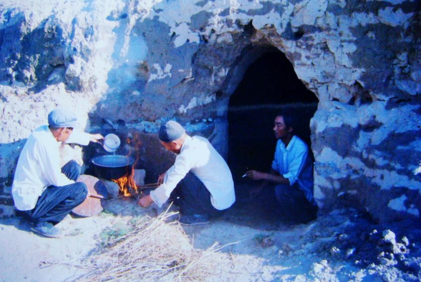1983年，“六老漢”一代治沙人在“地窩子”生活做飯。新華社發(fā)（八步沙林場(chǎng)供圖）