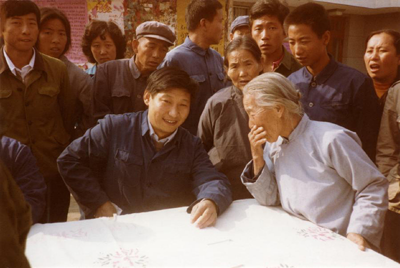 1983年，時(shí)任河北正定縣委書記的習(xí)近平（前排居中），臨時(shí)在大街上擺桌子聽取老百姓意見。