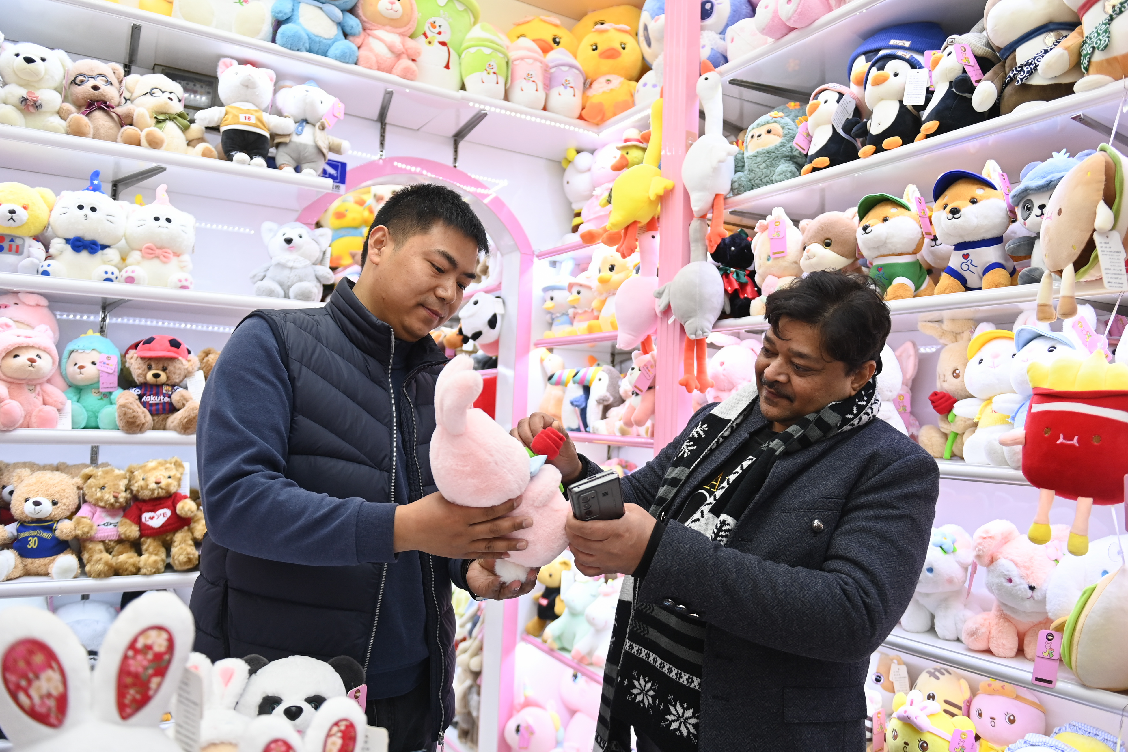 2023年2月2日，來(lái)自印度的客商（右）在義烏國(guó)際商貿(mào)城的一家玩具店鋪內(nèi)選購(gòu)。